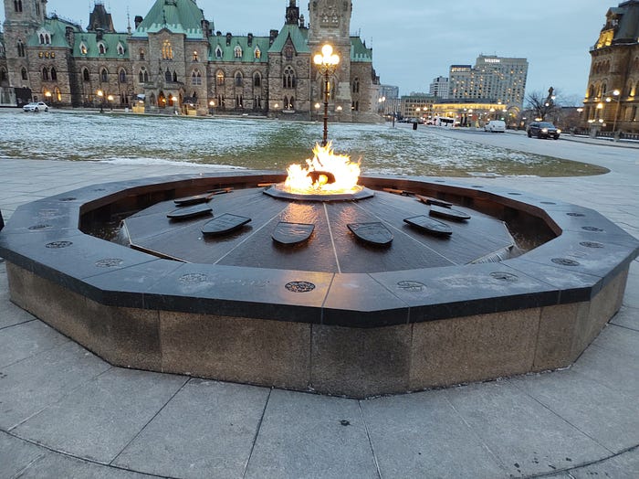 The Canadian Centennial Flame granite monument on Parliament Hill. It’s an ongoing fire using bio-gas, first lit in 1967, that doesn’t extinguish in the winter. The year that the province or territory joined Canada is carved into the granite in front of the shield. Photo Credit — Roxanne Joseph