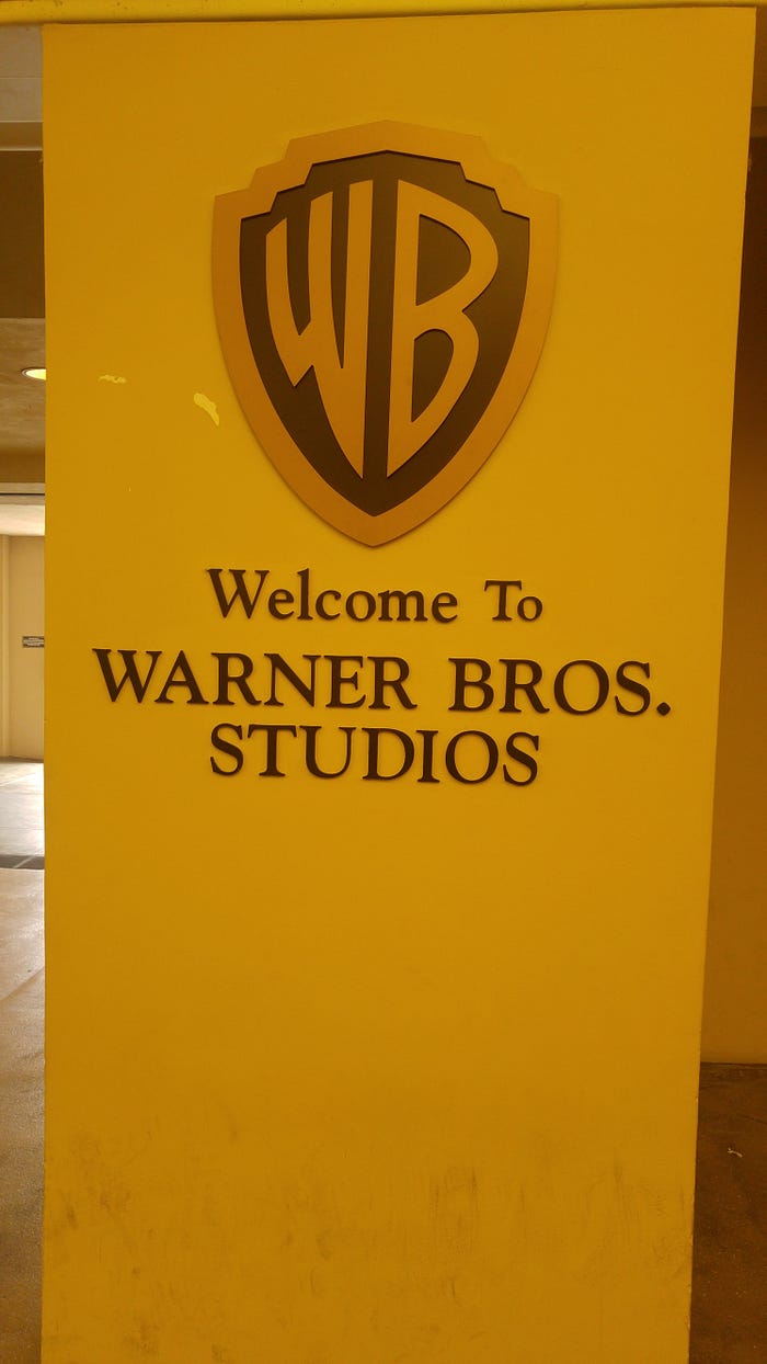A sign with Welcome to Warner Brothers Studios and the WB emblem